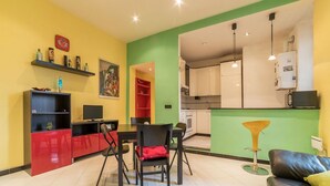 Una sala de estar moderna con comedor, cocina y una silla roja y negra.