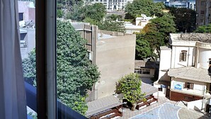 A view of high-rise buildings, a courtyard with a tree, and a building with a blue facade. - New Star Zamalek Hotel (Cairo)