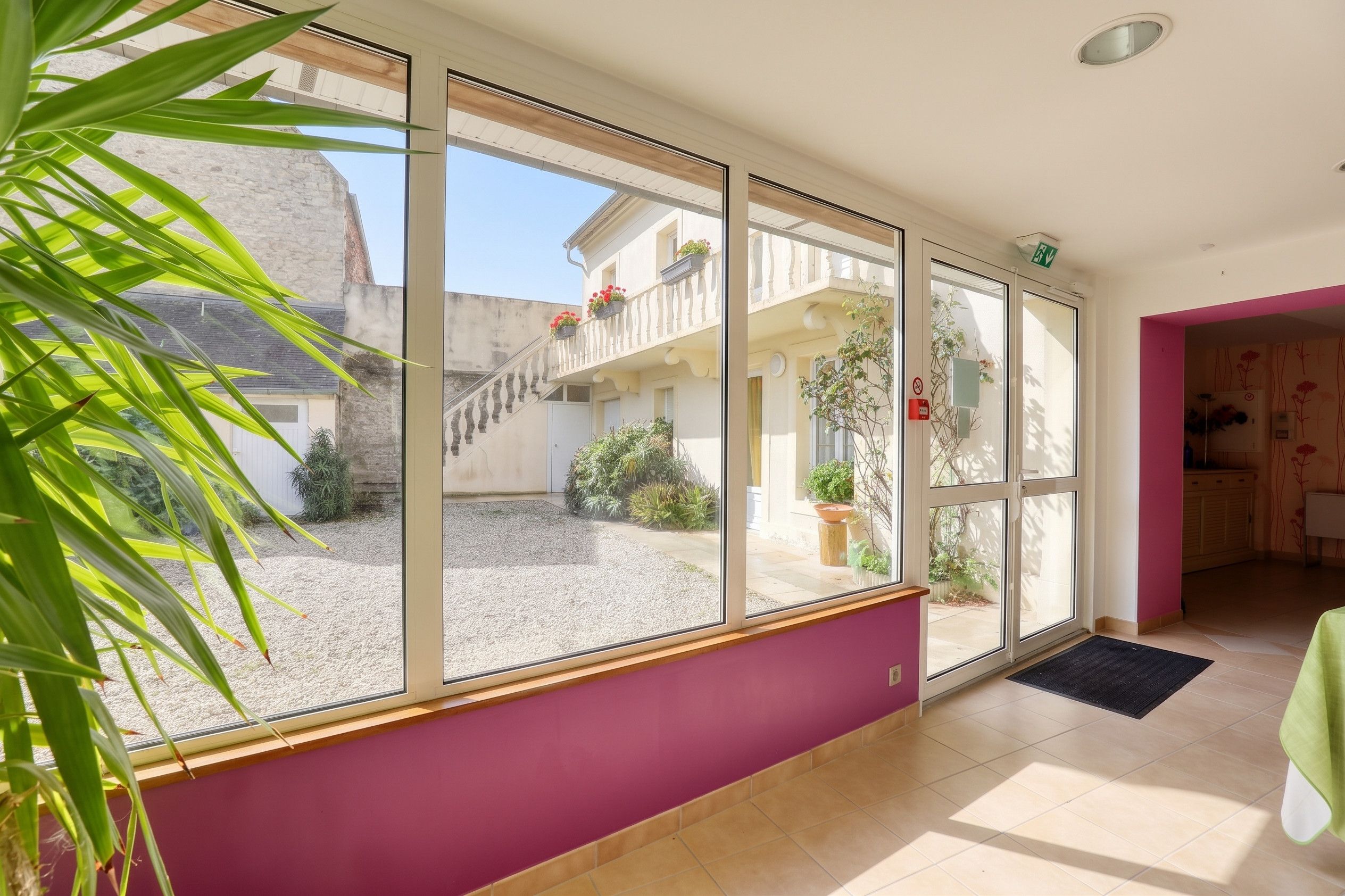 Una habitación con ventanas amplias, una escalera y vistas a un edificio.