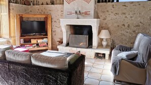 A living room with a fireplace, a television, and a sofa.