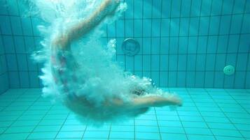 An underwater view of a swimming pool with grid lines on the floor and walls.