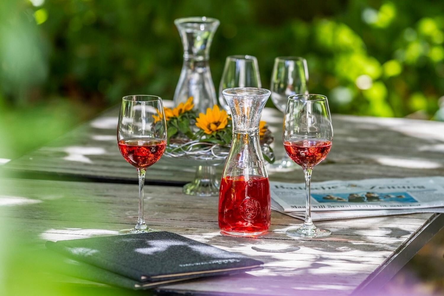 A table with two wine glasses, a decanter, and a menu.
