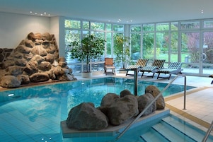 Una piscina techada, sillones reclinables de piscina