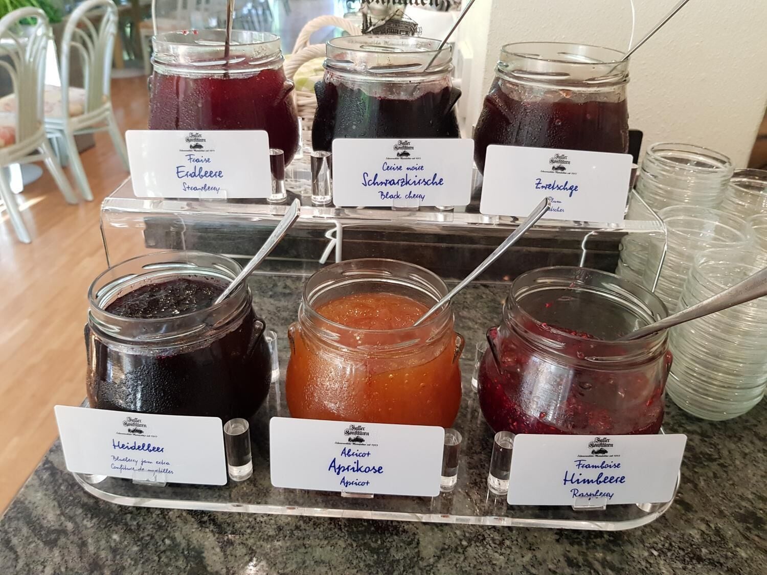 Una exhibición de diversas conservas de fruta con etiquetas en una tienda.