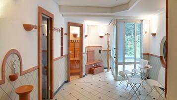 Relax in a stylish room with a geometric-patterned floor, a comfortable seating area, and a large window.