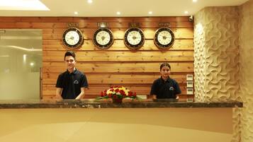 A reception desk with clocks displaying time in India, Russia, UK, and New York.