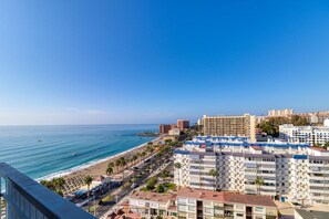 A coastal cityscape with a beachfront, high-rise buildings, and a clear sky.