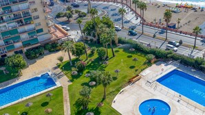 Vista aérea de un resort con varias piscinas, palmeras y una zona de playa.