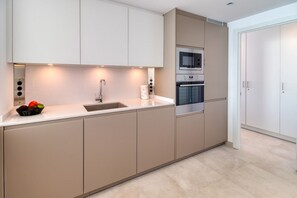 A modern kitchen with a built-in oven, microwave, and stainless steel sink.