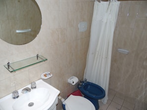 A bathroom with a sink, toilet, bidet, and a glass shelf. - Hotel San Francisco (San Juan)