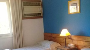 A hotel room with two beds, a bedside lamp, a bedside telephone, and a window with curtains. - Hotel San Francisco (San Juan)