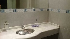 A bathroom with a sink, mirror, and tiled walls. - Hotel San Francisco (San Juan)
