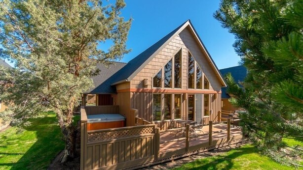 A cabin with a deck, a hot tub, and a large window. - Forest Ridge 2 Bedroom Home by RedAwning (Redmond)