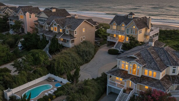 A coastal residential area with houses featuring multiple stories, a swimming pool, and a view of the ocean. - Point of View - Nags Head MP 15, Oceanfront, Ocean View, Elevator, Pool, Hot Tub, Gazebo (Nags Head)