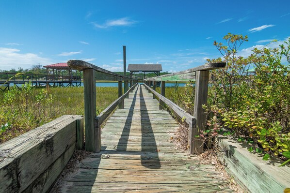 Un muelle de madera que conduce a un pabellón cubierto junto a un lago.