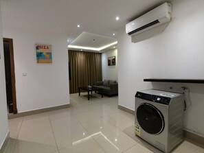 Un appartement moderne équipé d’un lave-linge, d’un canapé et d’un coin repas.