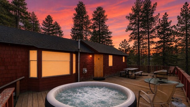 Eine Holterrasse mit Whirlpool, Sitzgelegenheiten im Freien und einem Gebäude mit Fenstern.