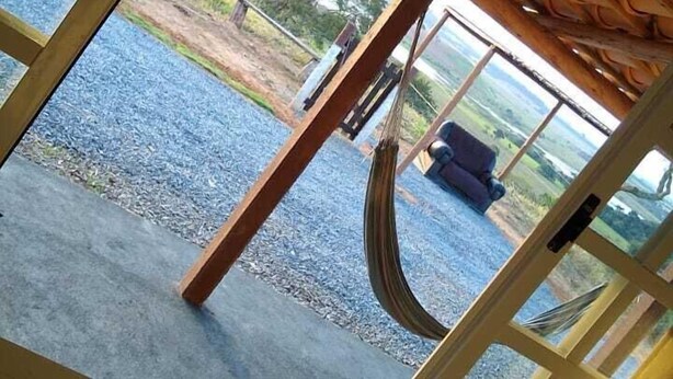 Vista a través de una ventana con techo de madera y un columpio.