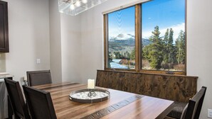 Un comedor con mesa de madera, sillas y un centro de mesa con velas.
