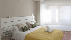 Une chambre d’hôtel avec un lit, une table de chevet et une fenêtre avec des rideaux.