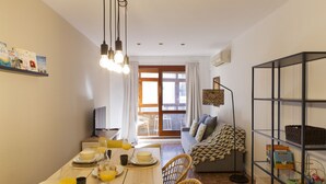 Un coin repas avec une table mise pour le petit-déjeuner, un canapé et une bibliothèque.