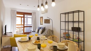 Un coin repas avec une table mise pour le petit-déjeuner, une bibliothèque et une vue sur l’extérieur.