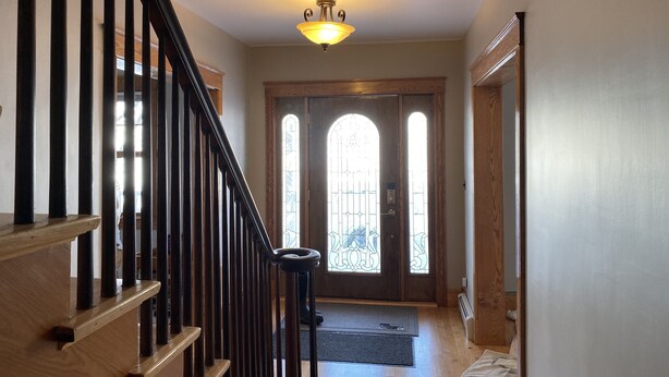 A staircase with wooden railings leading to a door with stained glass windows. - Large home walking distance to town and trails. 10 minutes to ski resorts. (Ironwood)