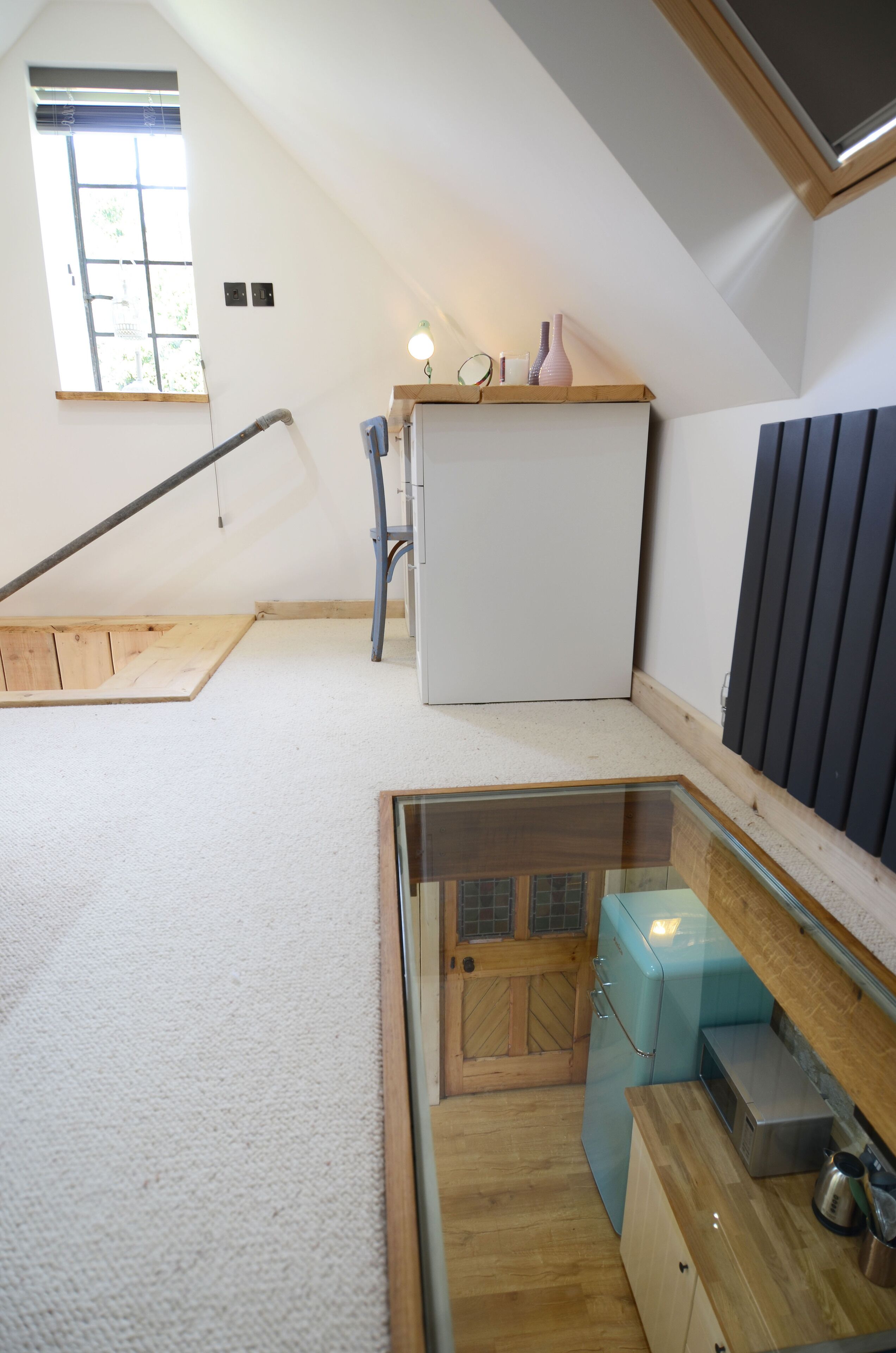 A compact kitchen with a built-in refrigerator, a wooden countertop, and a small window.