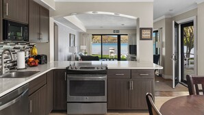 Een moderne keuken met uitzicht op een meer, een eethoek en een zithoek.