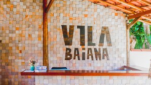 Una zona de recepción con un muro de mosaicos y el nombre "VILLA BAJANA" bien visible.