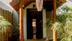 Una entrada de madera con techo de tejas y un colgante de luz.