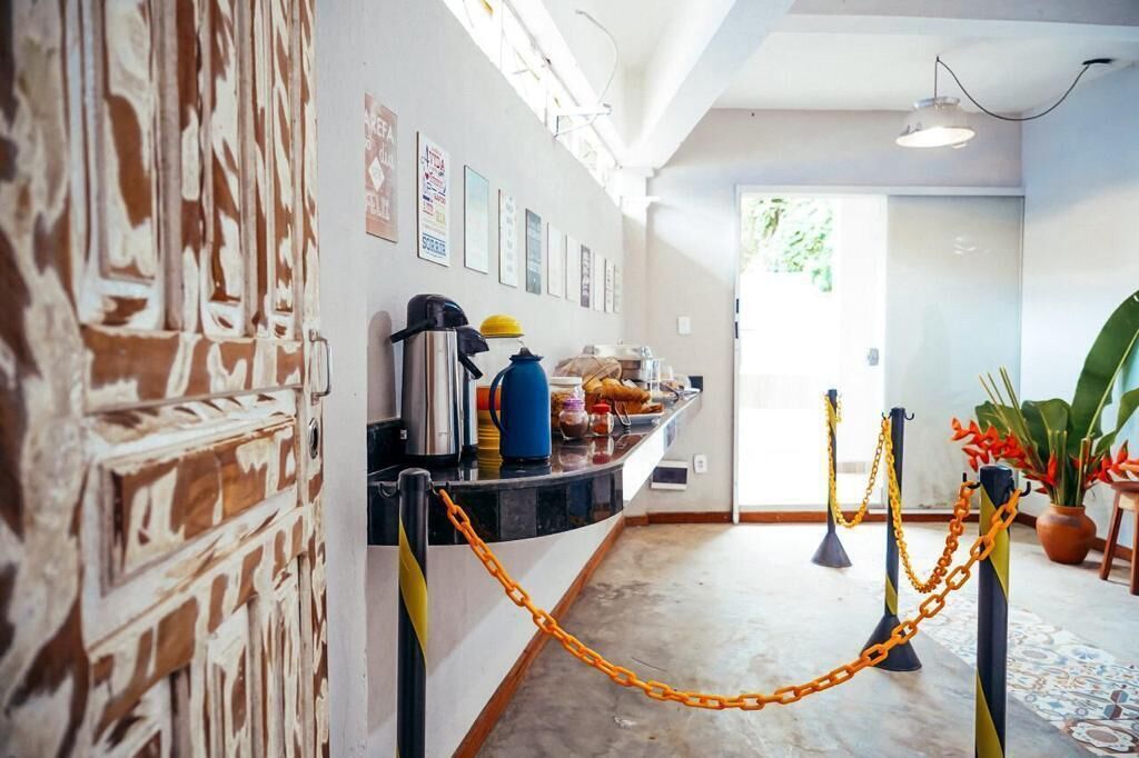 A hallway with a black counter, yellow chains, and a door leading to a bright room.