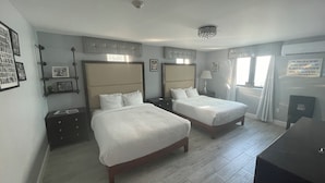 A hotel room with two beds, a desk, and a chair. - Dunns Josephine Hotel (Miami)