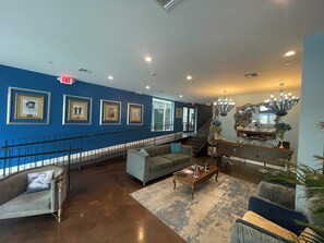 A spacious lobby with a blue accent wall, a staircase, and a chandelier. - Dunns Josephine Hotel (Miami)