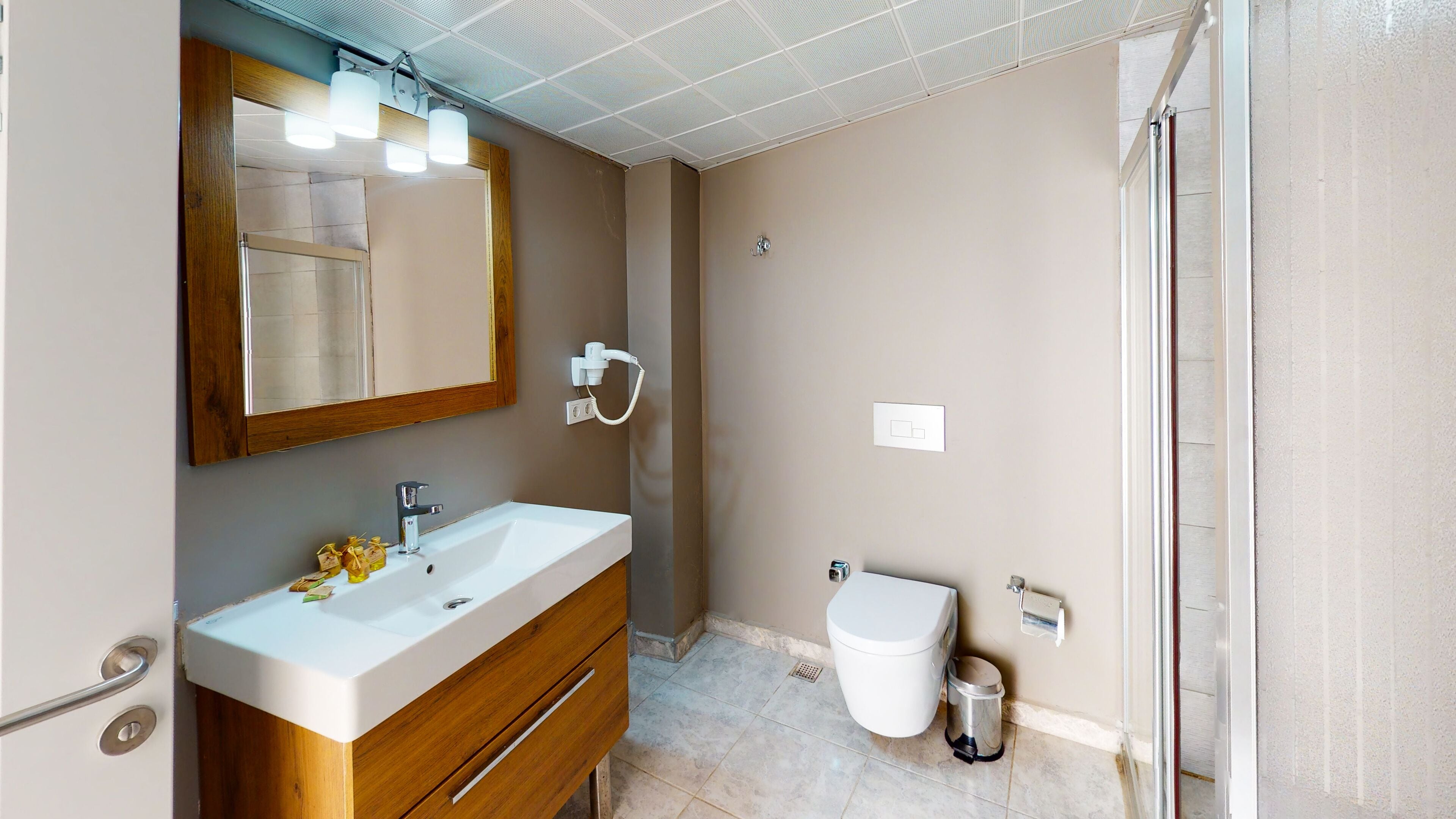 deluxe studio suite | bathroom | shower, slippers, towels