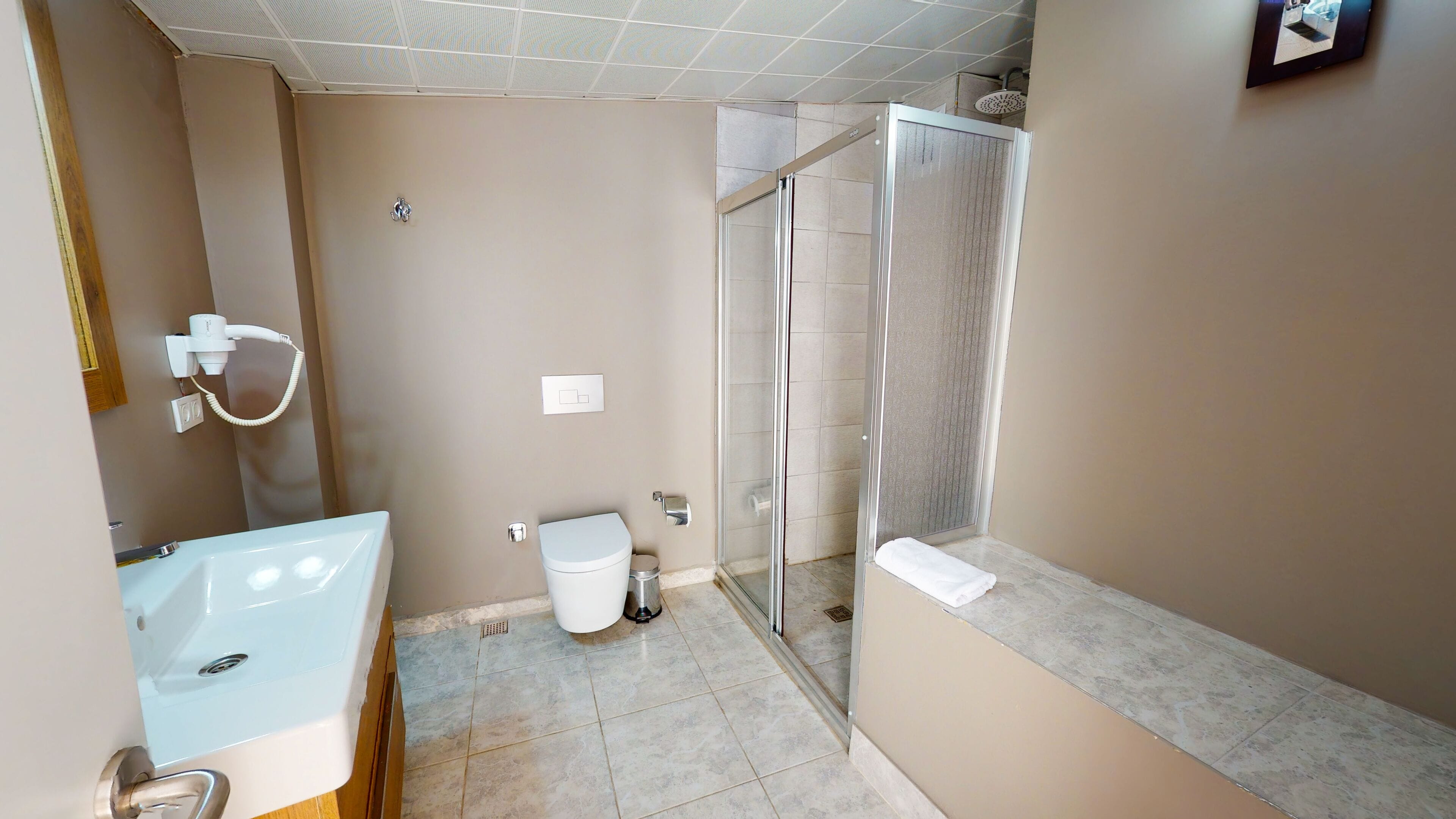 deluxe studio suite | bathroom | shower, slippers, towels