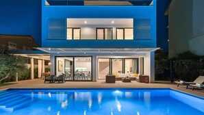A modern two-story house with a swimming pool in the foreground. - Villa Lodi - new modern villa  few steps from beach with heated pool (Kaštel Štafilić)