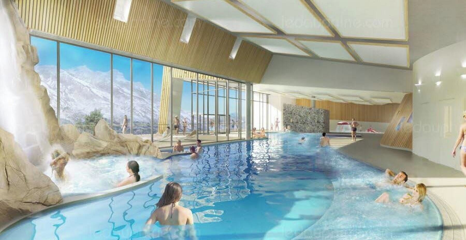 Una piscina interior con vistas despejadas a montañas a través de amplios ventanales, techo de madera y una cascada.