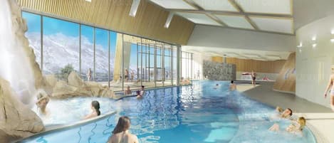 Una piscina interior con vistas despejadas a montañas a través de amplios ventanales, techo de madera y una cascada.