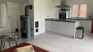 Una cocina moderna con estufa integrada, microondas y un basurero de acero inoxidable.