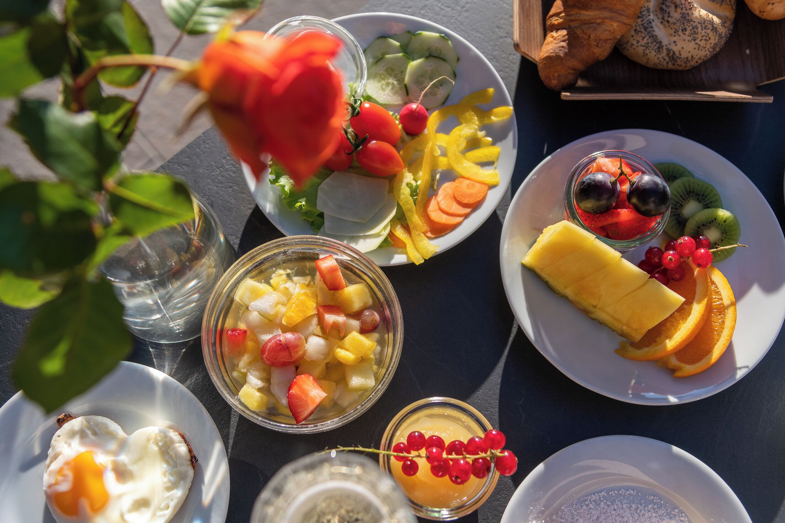 A variety of breakfast items including fruit, eggs, and pastries on a table.