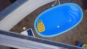 A small indoor pool with a pineapple decoration, a white chair, and a blue edge. - Recanto do Tanaca Holiday homes (Olímpia)