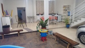 A spacious indoor area with a pool, a dining area, and a staircase. - Recanto do Tanaca Holiday homes (Olímpia)