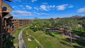 Un hotel con una carretera curva, césped verde y árboles.