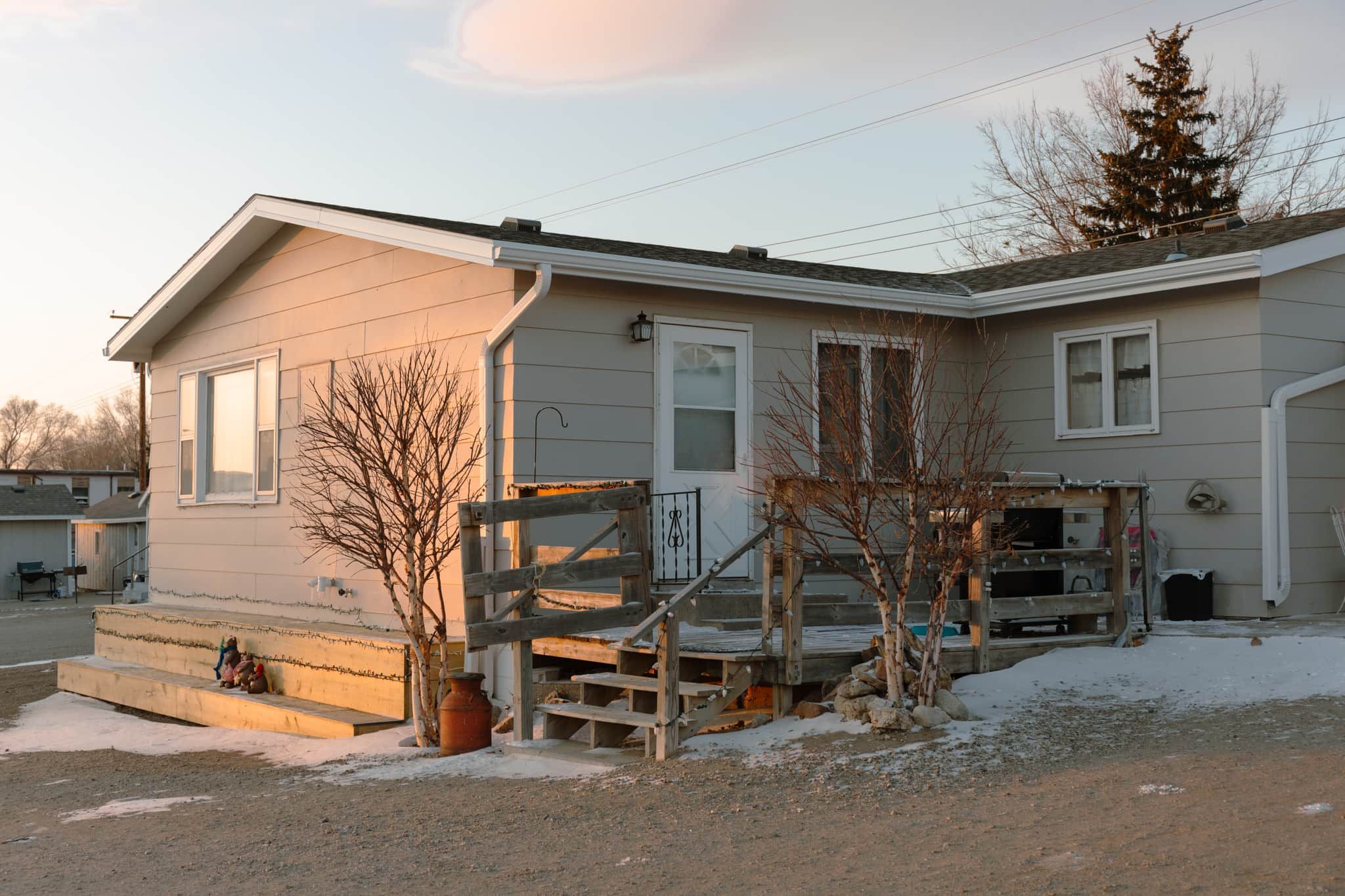 A single-story house with a front porch, a small staircase, and a garage.