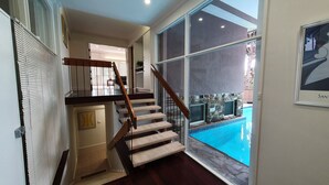 A staircase leading to a second floor with a view of a swimming pool. - Toorak Luxury Living (Toorak)