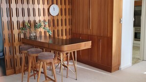 A kitchen with a wooden table, stools, and a clock on the wall. - Toorak Luxury Living (Toorak)