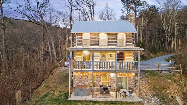 Eine zweistöckige Blockhütte mit Balkon, Grill und einer amerikanischen Flagge.