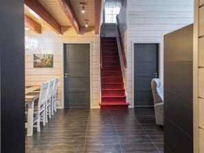 A staircase with red steps leading to a landing, flanked by two doors.