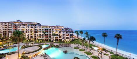 Un resort con varias edificaciones, una piscina y una playa.